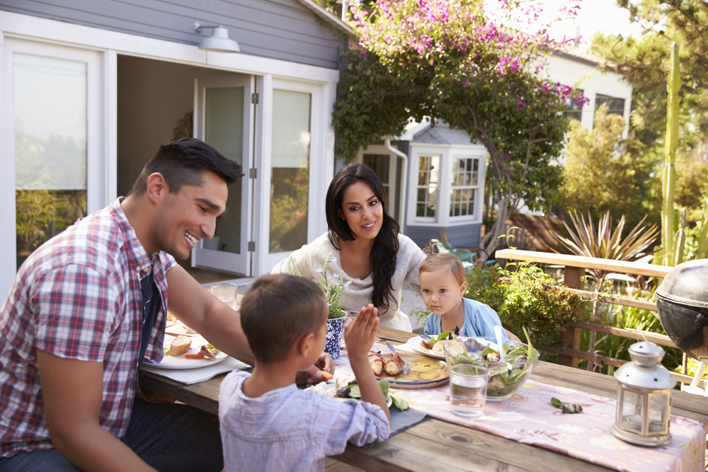 Family At Home Eating Outdoor Meal In Garden Together Idaho Firewise